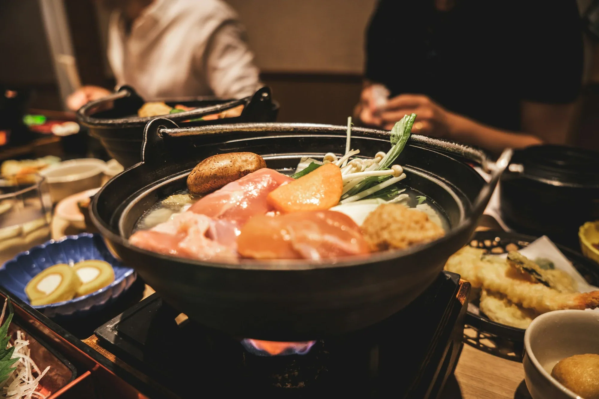 Nồi lẩu sôi giữa bàn,
bếp than hồng cho cả nhóm